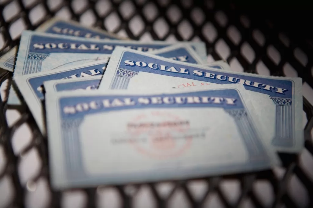 a close up shot of several Social Security cards on a chequered mat.