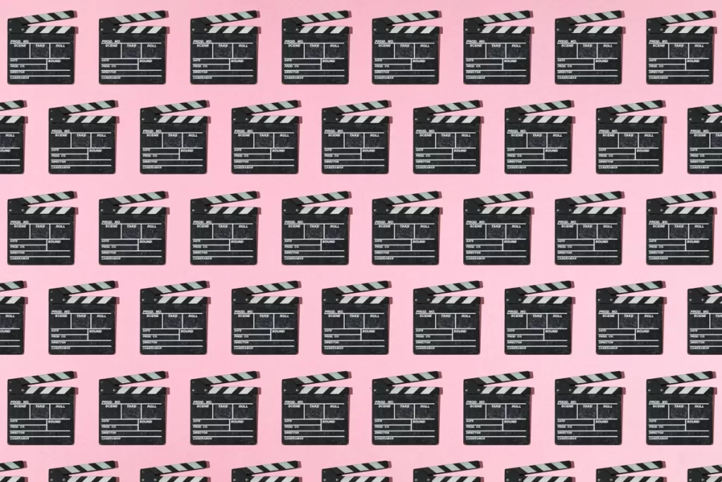 Wooden old movie clapperboard pattern with hard shadow on pink background. Concept of film industry, cinema, entertainment, and Hollywood.