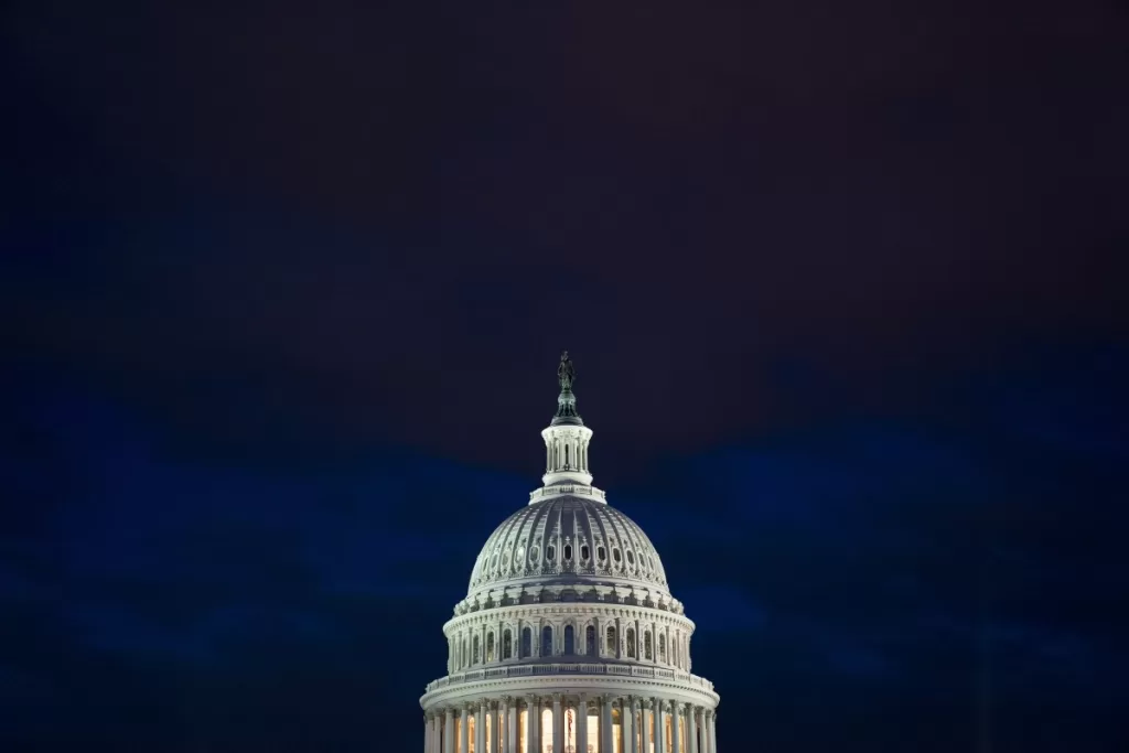 The U.S. Capitol building illuminated against a dark sky in Washington, D.C.,