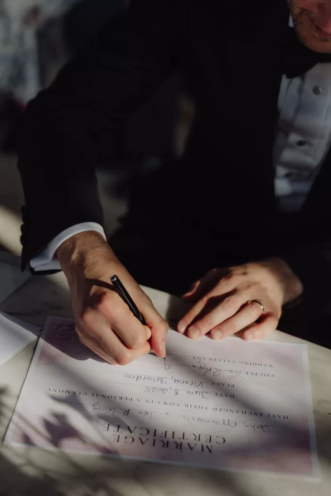 Closeup of a person signing a marriage certificate