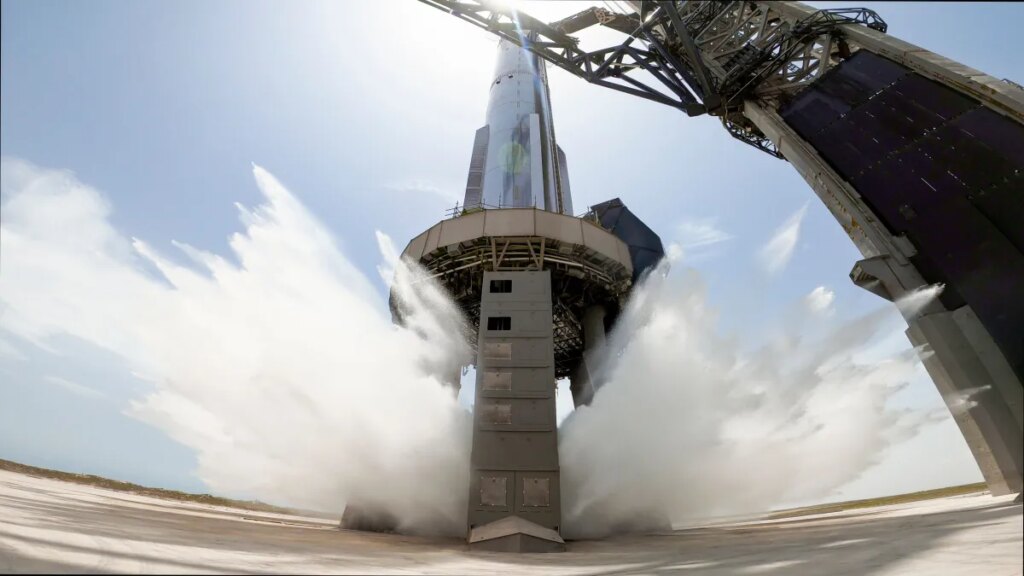 A view of SpaceX's starship system on the launchpad with the water-cooling flame deflector system active
